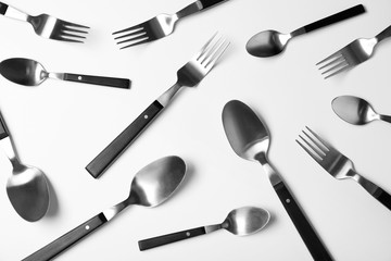 Set of new metal cutlery on white background, top view