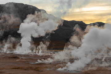 The silhouette of unrecognizable tourists walking through the water vapor of the Tatio Geyser Field, the highest in the world, Atacama Desert, Chile, South America.