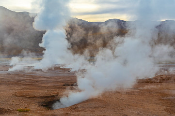 Landscape of the Tatio Geysers with its fumaroles and vapor trails at sunrise, Atacama Desert, Chile.