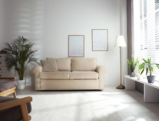 Living room interior with comfortable sofa near window