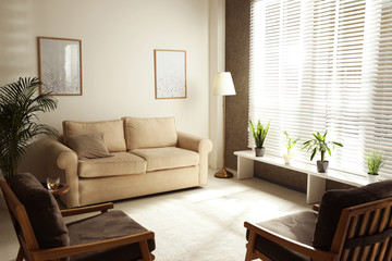 Living room interior with comfortable sofa and armchairs