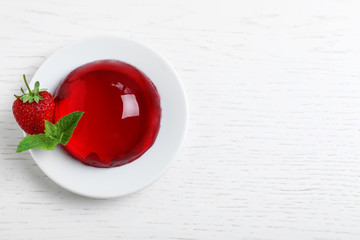 Delicious fresh red jelly with berries and mint on white wooden table, top view. Space for text - obrazy, fototapety, plakaty