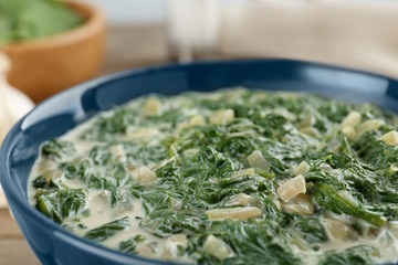 Tasty spinach dip in bowl on table, closeup
