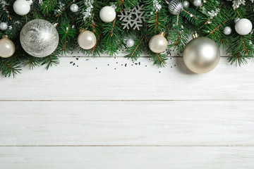 Fir tree branches with Christmas decoration on white wooden background, flat lay. Space for text