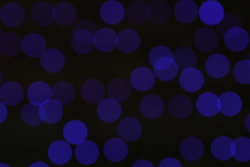 Blurred view of blue Christmas lights on dark background