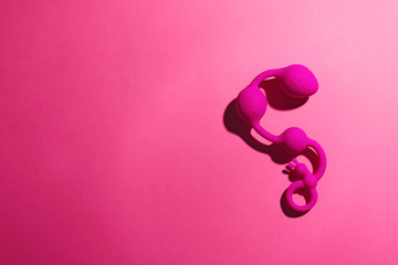 Anal balls on pink background, top view with space for text. Sex toy