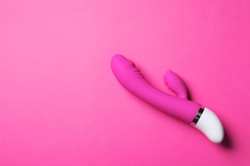 Dildo on pink background, top view with space for text. Sex toy