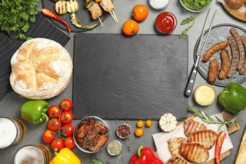 Flat lay composition with barbecued meat and vegetables on grey table. Space for text