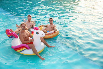 Happy young friends relaxing in swimming pool