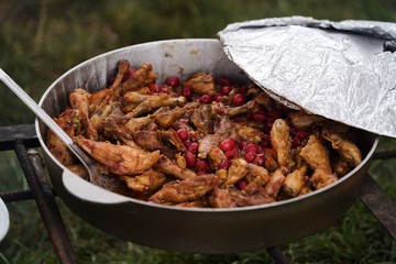 Open air kitchen at party. Cooking chicken meat on fire for Pilaf dish