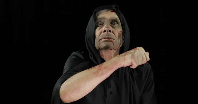 Old executioner Halloween makeup and costume. Elderly man with blood on his face