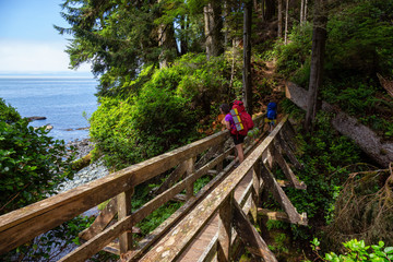 Adventurous female is hiking Juan de Fuca Trail on the Pacific Ocean Coast during a sunny summer day. Taken near Port Renfrew, Vancouver Island, BC, Canada.