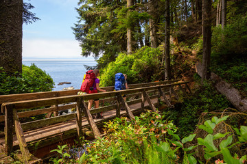 Adventurous female is hiking Juan de Fuca Trail on the Pacific Ocean Coast during a sunny summer day. Taken near Port Renfrew, Vancouver Island, BC, Canada.