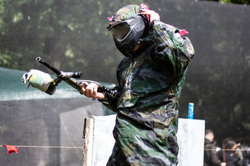 Injured paintball player. The equipped warrior leaves the battlefield. A guy in a mask and with a...