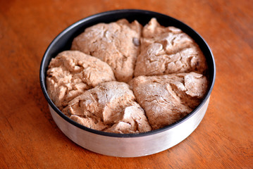 The dough on a tray on the table is ready for baking.