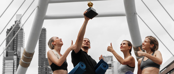 caucasian yoga team celebration the winning trophy recieve from yoga competition championship