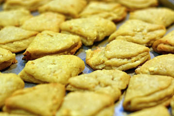 Freshly baked yellow cookies on a baking sheet, closeup.