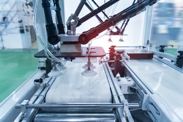 automatic robot with vacuum suckers and conveyor in Production of candy in a manufacture factory for the food industry