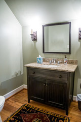small guest bathroom with a mirror, sink and vanity and granite countertop