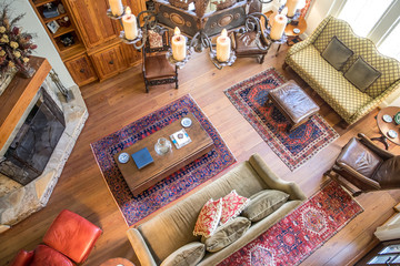 aerial view of a spacious living room with a lodge cabin style with earth-tone furniture and a fireplace