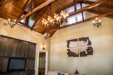 Living room custom customized copper and iron lighting fixture equipment hung from the vaulted wood plank ceiling
