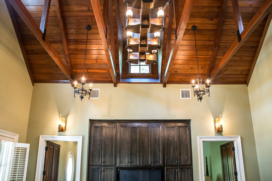 Living room custom customized copper and iron lighting fixture equipment hung from the vaulted wood plank ceiling