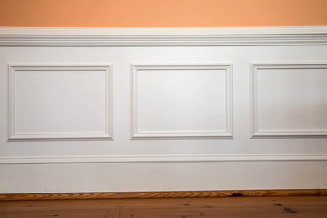 white wainscoting and chair rail on wall of orange peach dining living room of home house