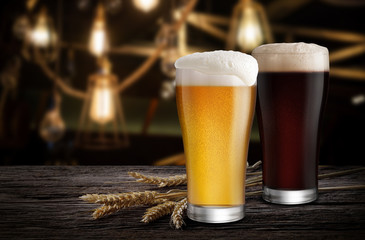 Glasses of Light Beer and Dark Beer with wheat on the bar counter in the restaurant at night, with copy space