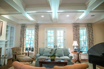 large formal living room in a spacious home. Coffered ceiling and a lot of natural light from the large windows. - obrazy, fototapety, plakaty