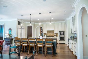 Custom cream kitchen with pendant light and double island with barstool seating