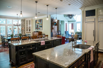 Custom cream kitchen with pendant light and double island with barstool seating