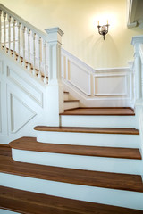 painted and natural stained wood stairs. Classic and tradition design with ornate banister