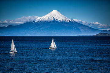 Two sailboats sail in front of snow capped Orsono Volcano in Chile.jpg