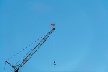 Metal construction crane viewed from below against cloudless blue sky