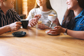 Closeup image of three people enjoyed talking and drinking coffee together in cafe