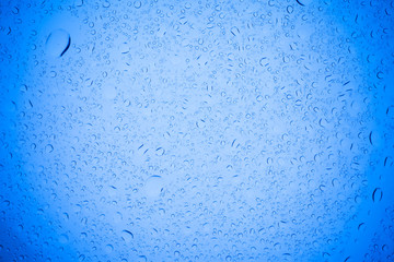 Rain droplets on blue glass background, Water drops on blue glass.