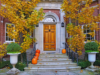 front steps of large brick house with pumpkins
