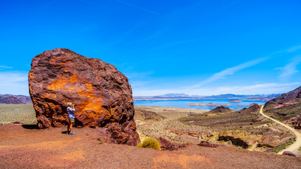 A woman taking a picture of Lake Mead from the Historic Railroad Hiking Trail near the Hoover Dam between Nevada and Arizona, USA