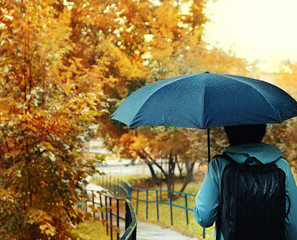 women with black umbrella in rain. rainy background, man and umbrella. rainy weather, fall time season. autumn rain backdrop.  shallow depth, soft selective focus