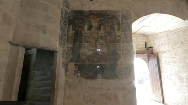 woman is photographing by smartphone ancient fresco with christianity theme on wall