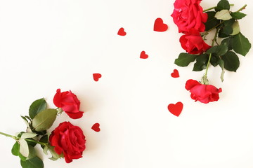 Red roses and red hearts decor for Valentine's day, wedding on white background . Top view. Copy space