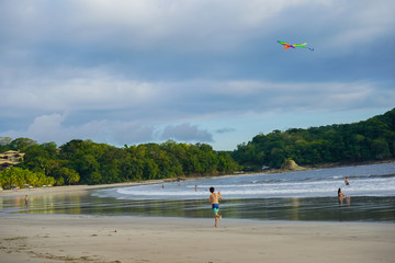 Happy kids playing with a kite in a beach