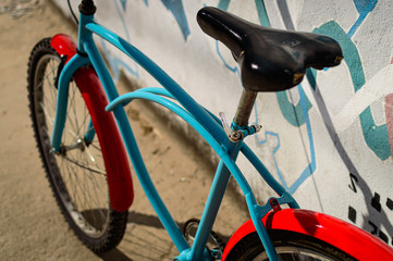 Asiento de bicicleta celeste y roja alegre y caribeña