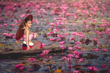Fototapete Asia women on the boat in the lotus pond. She wears Thai traditional dresses. © Ninja SS