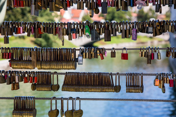 Love padlocks on the fence of the bridge over the river in Ljubljana