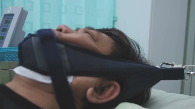 Physiotherapy patient   Being treated  by neck Therapy Physiotherapy Machine on the hospital bed