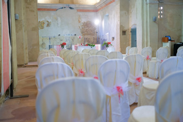 interno di chiesa addobbata con fiori e sedie bianche