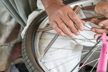 Mechanic repairing bicycle rear wheel