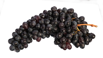 bunch of ripe black grapes on a white background