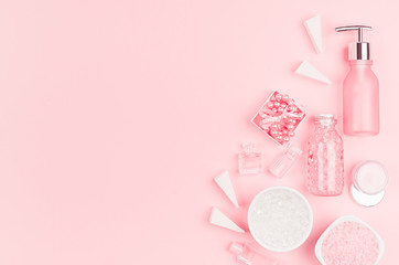 Different cosmetic products and accessories in pink and silver color on soft light pink background, copy space, top view.